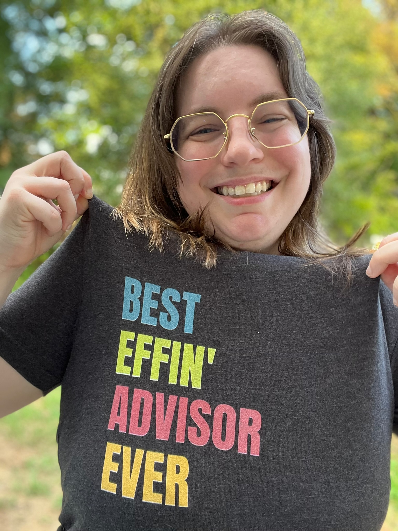 Me smiling while pulling my shirt into view. The shirt reads best effin advisor ever