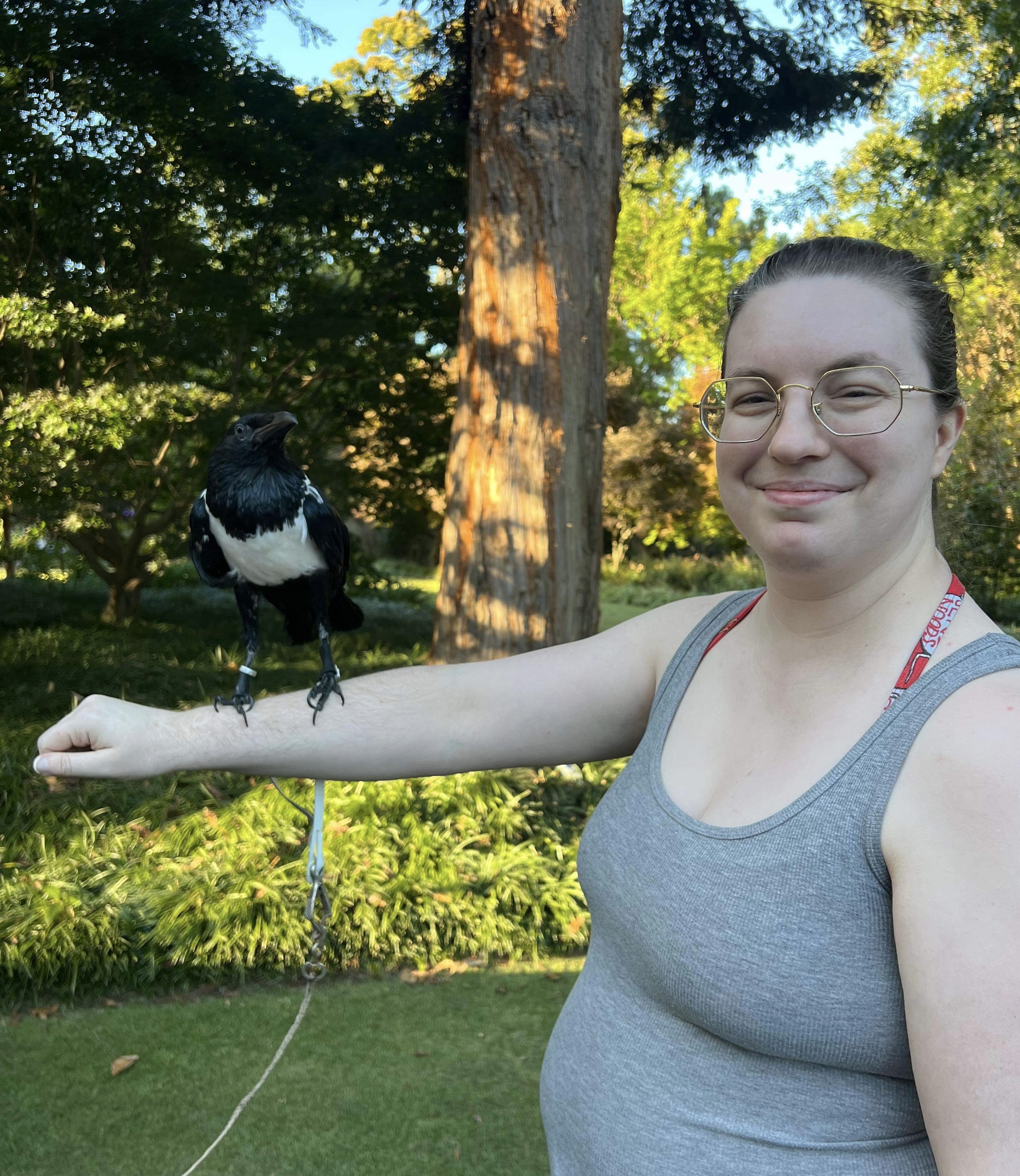 Me with my arm outstretched and a calm raven on my arm